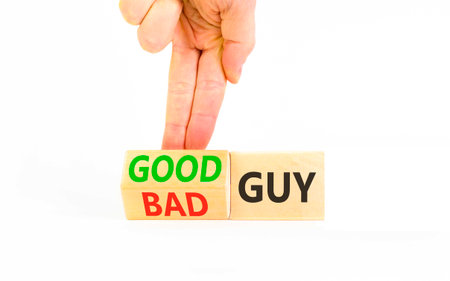 Good or bad guy symbol. Concept words Bad guy to Good guy on beautiful wooden cubes. Beautiful white background. Businessman's hand. Business psychological good or bad guy concept. Copy space.の写真素材