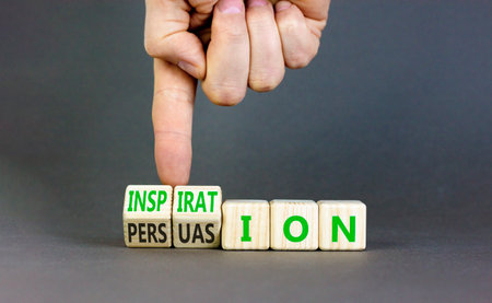 Persuasion or inspiration symbol. Concept words Persuasion and Inspiration on wooden cubes. Beautiful gray background. Psychologist hand. Psychology persuasion inspiration concept. Copy space.の写真素材