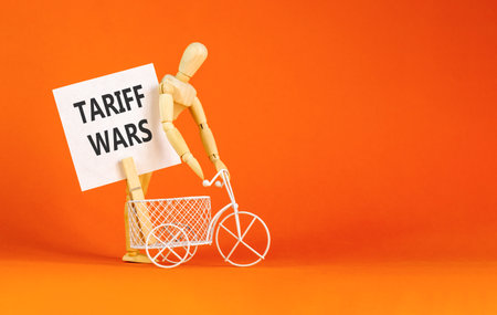 Trade tariff wars symbol. Concept word Tariff wars on beautiful white paper. Beautiful wooden clothespin. Businessman's model. Beautiful orange background. Business tariff wars concept. Copy space.の写真素材