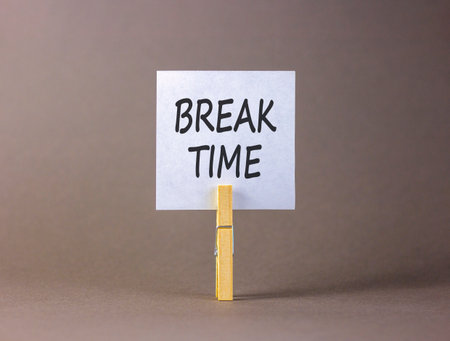 Break time symbol. Concept Break word time on beautiful white paper. Beautiful wooden clothespin. Beautiful gray background. Business break time concept. Copy space.の写真素材