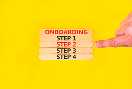 Time to step 2 onboarding symbol. Concept words Onboarding step 2 on beautiful wooden block. Businessman's hand. Beautiful yellow background. Business success step 2 onboarding concept. Copy space.の写真素材