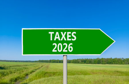 Taxes 2026 new year symbol. Concept words Taxes 2026 on beautiful green road sign. Beautiful green grass field forest and blue sky background. Business and taxes 2026 new year concept. Copy space.の写真素材