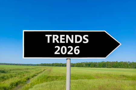 Trends 2026 new year symbol. Concept words Trends 2026 on beautiful black road sign. Beautiful green grass field forest and blue sky background. Business and Trends 2026 new year concept. Copy space.の写真素材