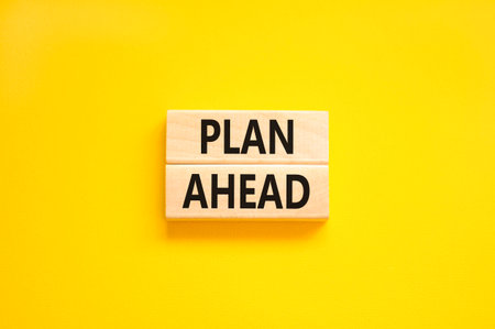 Plan ahead symbol. Concept word Plan ahead on beautiful wooden blocks. Beautiful yellow paper background. Business plan ahead concept. Copy space.の写真素材