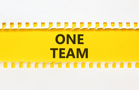 One team symbol. Concept word One team on beautiful white paper. Beautiful yellow paper background. Business one team concept. Copy space.の写真素材
