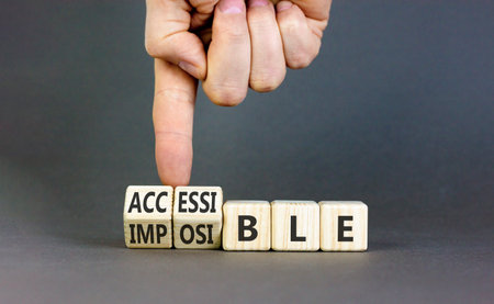 Accessible or impossible symbol. Concept words Accessible or Impossible on wooden blocks. Gray table gray background. Business accessible or impossible concept. Copy space.の写真素材