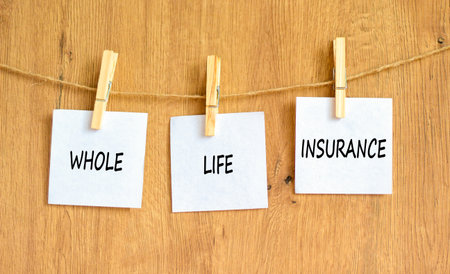 Whole life insurance symbol. Concept words Whole life insurance on beautiful white paper on clothespin. Beautiful wooden background. Business whole life insurance concept. Copy space.の写真素材