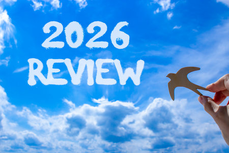 2026 Review symbol. Concept words 2026 Review on beautiful blue sky. Beautiful blue sky background. Businessman's hand holds wooden bird. Business and 2026 review concept. Copy space.の写真素材