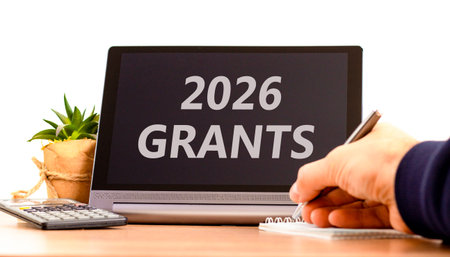 2026 Grants symbol. Concept words 2026 Grants on beautiful black tablet screen. Beautiful white background. Businessman's hand. Business and 2026 grants concept. Copy space.の写真素材