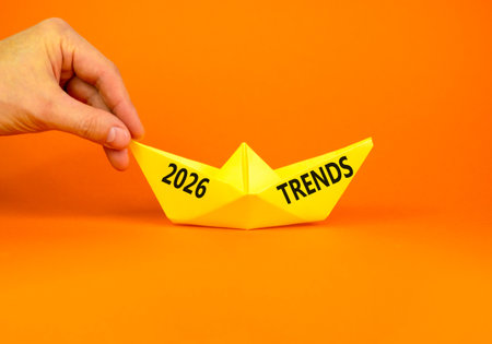 2026 Trends new year symbol. Concept words 2026 Trends on beautiful yellow paper boat. Beautiful orange paper background. Businessman's hand. Business and 2026 Trends new year concept. Copy space.の写真素材