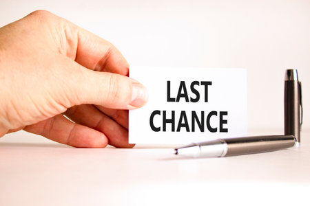 Last chance symbol. Concept word Last chance on beautiful white card. Beautiful black pen. Beautiful white paper background. Businessman's hand. Business last chance concept. Copy space.