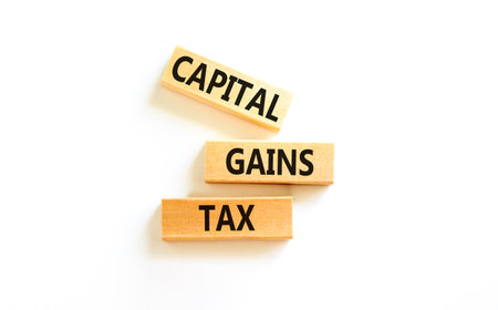 Capital gains tax symbol. Concept words Capital gains tax on beautiful wooden block. Beautiful white table white background. Business and capital gains tax concept. Copy space.の写真素材