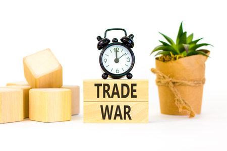 Trade war symbol. Concept word Trade war on beautiful wooden blocks. Beautiful white paper background. Beautiful black alarm clock. Business trade war concept. Copy space.の写真素材