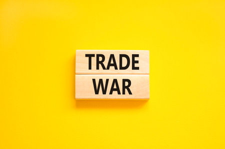 Trade war symbol. Concept word Trade war on beautiful wooden blocks. Beautiful yellow paper background. Business trade war concept. Copy space.の写真素材
