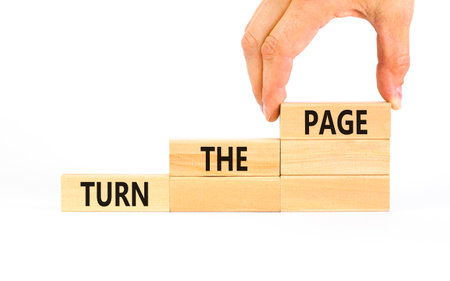 Turn the page symbol. Concept words Turn the page on beautiful wooden block. Businessman's hand. Beautiful white background. Business motivational lifestyle turn the page concept. Copy space.の写真素材
