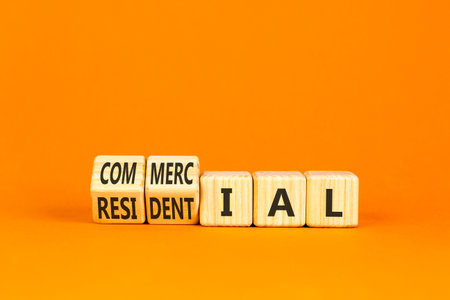 Commercial or residential symbol. Concept words Commercial or Residential on beautiful wooden blocks. Beautiful orange background. Business commercial or residential concept. Copy space.の写真素材