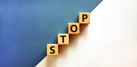 Stop symbol. Concept word Stop on beautiful wooden blocks. Beautiful white and blue background. Business, lifestyle, support and stop concept. Copy space.の写真素材