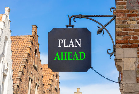 Plan ahead symbol. Concept word Plan ahead on beautiful black sign on street in Brugge. Beautiful blue sky and buildings background. Business plan ahead concept. Copy space.の写真素材