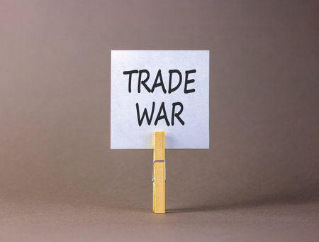 Trade war symbol. Concept word Trade war on beautiful white paper. Beautiful wooden clothespin. Beautiful gray background. Business trade war concept. Copy space.の写真素材