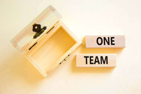 One team symbol. Concept word One team on beautiful wooden blocks. Beautiful white paper background. Empty wooden beautiful chest. Business one team concept. Copy space.の写真素材