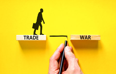 Trade war symbol. Concept word Trade war on beautiful wooden blocks. Beautiful yellow paper background. Businessman's icon. Business trade war concept. Copy space.の写真素材