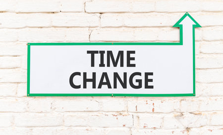 Time change symbol. Concept word Time change on beautiful white sign on white brick wall. Beautiful white brick wall background. Business time change concept. Copy space.の写真素材