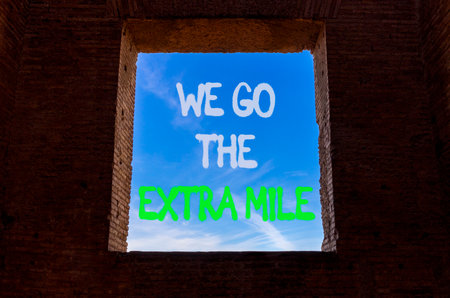 Support, help we go the extra mile symbol. Concept words We go the extra mile on beautiful window in ancient brick wall. Beautiful blue sky background. Business we go the extra mile concept Copy spaceの写真素材