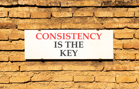 Consistency is the key symbol. Concept words Consistency is the key on beautiful white marble sign...