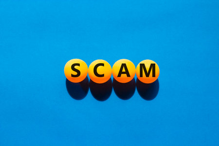 Scam symbol. Concept word Scam on beautiful yellow ping pong balls. Beautiful blue table blue background. Business, lifestyle, support and scam concept. Copy space.の写真素材