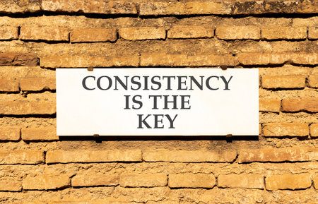 Consistency is the key symbol. Concept words Consistency is the key on beautiful white marble sign...