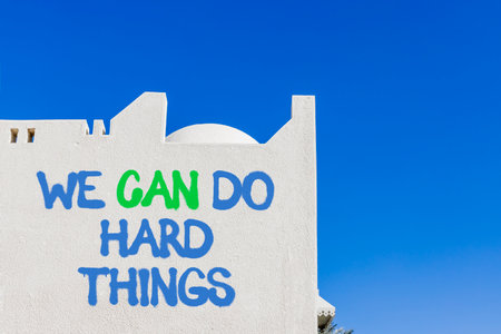 Support, help we can do hard things symbol. Concept words We can do hard things on beautiful white wall. Beautiful blue sky background. Business we can do hard things concept. Copy space.の写真素材