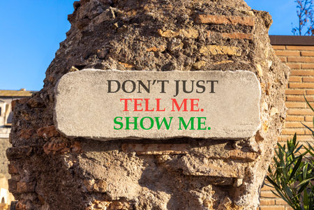 Tell or show symbol. Concept words Do not just tell me, show me marble sign plate. Beautiful brick column background. Business tell or show concept. Copy space.の写真素材