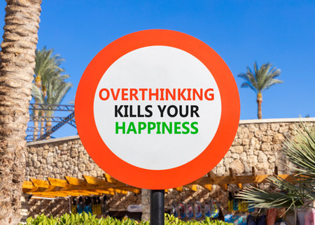 Overthinking kills your happiness symbol. Concept words Overthinking kills your happiness on road sign. Beautiful palm trees background. Business overthinking kills happiness concept. Copy space.の写真素材
