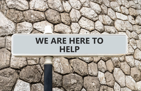Support, help and we are here to help symbol. Concept words We are here to help on gray beautiful road sign. Beautiful stone wall background. Business we are here to help concept. Copy space.の写真素材