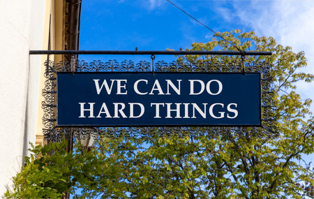 Support, help we can do hard things symbol. Concept words We can do hard things on black beautiful road sign. Beautiful blue sky trees background. Business we can do hard things concept. Copy space.の写真素材