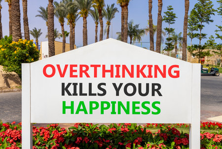 Overthinking kills your happiness symbol. Concept words Overthinking kills your happiness on road sign. Beautiful palm trees background. Business overthinking kills happiness concept. Copy space.の写真素材