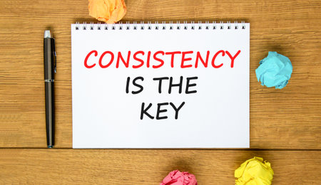 Consistency is the key symbol. Concept words Consistency is the key on beautiful white note. Beautiful wooden background. Black pen. Business consistency is the key concept. Copy space.の写真素材