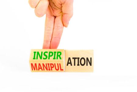 Inspiration or manipulation symbol. Concept words Inspiration and Manipulation on wooden cubes. Beautiful white background. Psychologist hand. Psychology inspiration manipulation concept. Copy space.の写真素材