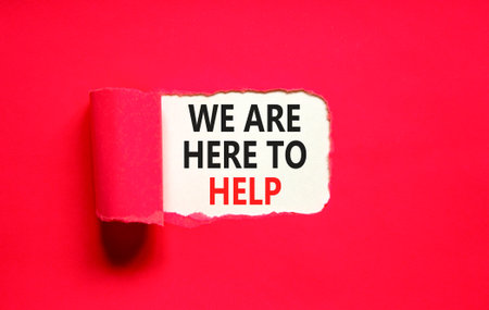 Support, help and we are here to help symbol. Concept words We are here to help on beautiful white paper. Beautiful red paper background. Business we are here to help concept. Copy space.の写真素材
