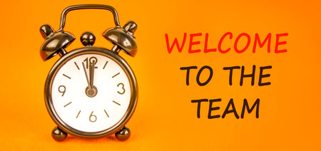 Support, help welcome to the team symbol. Concept words Welcome to the team on beautiful orange paper. Beautiful orange background. Black alarm clock. Business welcome to the team concept. Copy space.の写真素材