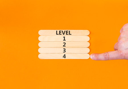 Time to level 4 symbol. Concept word Level 1 2 3 4 on beautiful wooden sticks. Businessman's hand....