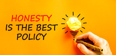 Honesty is the best political symbol. Concept words Honesty is the best policy on orange paper. Beautiful orange background. Businessman's hand. Business honesty is the best policy concept. Copy space.の写真素材