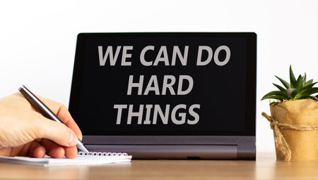 Support, help we can do hard things symbol. Concept words We can do hard things on beautiful tablet. Beautiful white background. Businessman's hand. Business we can do hard things concept. Copy space.の写真素材