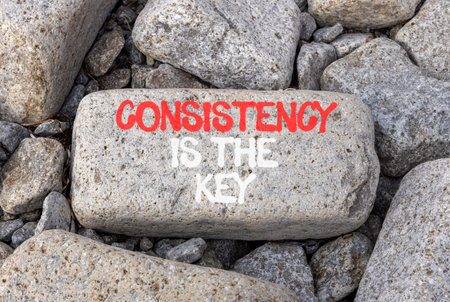 Consistency is the key symbol. Concept words Consistency is the key on beautiful gray stone. Beautiful gray stones background. Business consistency is the key concept. Copy space.の写真素材