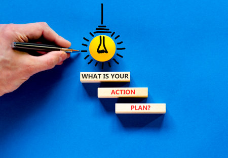 What is your action plan symbol. Concept words What is your action plan on beautiful blocks. Beautiful blue background. Businessman's hand. Business what is your action plan concept. Copy space.の写真素材