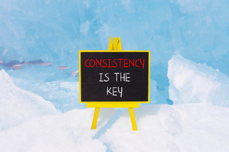 Consistency is the key symbol. Concept words Consistency is the key on beautiful blackboard. Beautiful blue Baikal ice background. Business consistency is the key concept. Copy space.の写真素材
