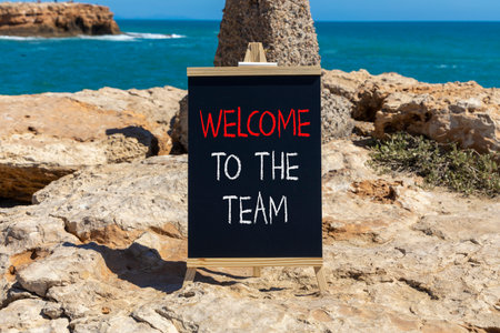 Support, help welcome to the team symbol. Concept words Welcome to the team on beautiful blackboard. Beautiful stone and blue sky, sea background. Business welcome to the team concept. Copy space.の写真素材