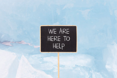 Support, help and we are here to help symbol. Concept words We are here to help on beautiful blackboard. Beautiful blue Baikal ice background. Business we are here to help concept. Copy space.の写真素材