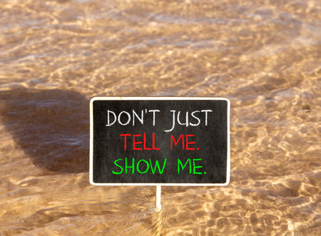 Tell or show symbol. Concept words Do not just tell me, show me on beautiful blackboard. Beautiful Red sea water background. Business tell or show concept. Copy space.の写真素材