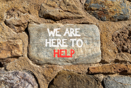Support, help and we are here to help symbol. Concept words We are here to help on beautiful gray stone. Beautiful stone wall background. Business we are here to help concept. Copy space.の写真素材